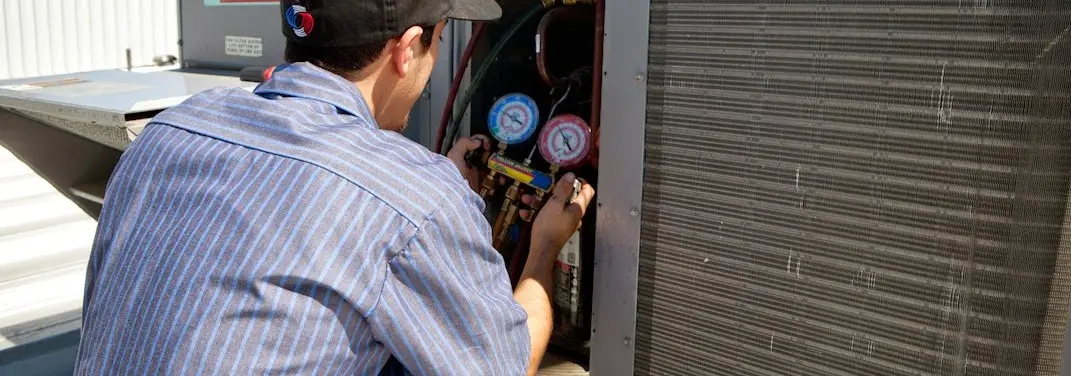 HVAC technician servicing a condenser unit in Fairfield